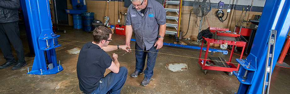 Two Allied workers measuring and ensuring proper lift alignment during an installation