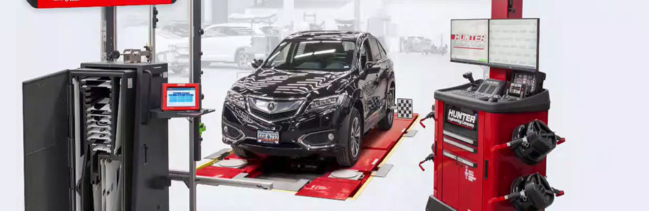 Vehicle in tire shop sitting on a Hunter wheel alignment system pad and Hunter system cart next to the car.