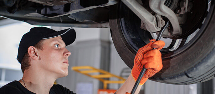 Allied Customer working on the underside of a car on an automotive lift