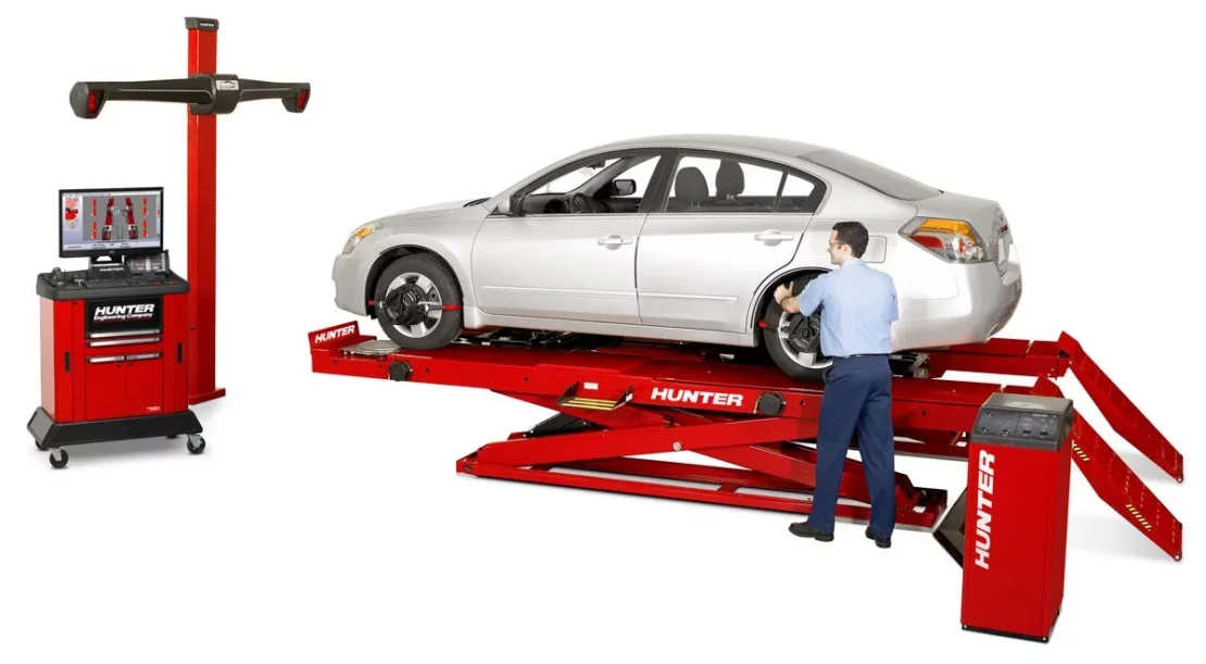 Car maintenance representative performing a wheel alignment