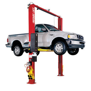 A standard light-duty passenger truck is lifted on a red Rotary Lift SPO10 model.