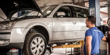 Mechanic using a low-rise automotive lift