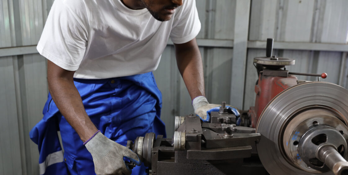 A technician is using a brake lathe